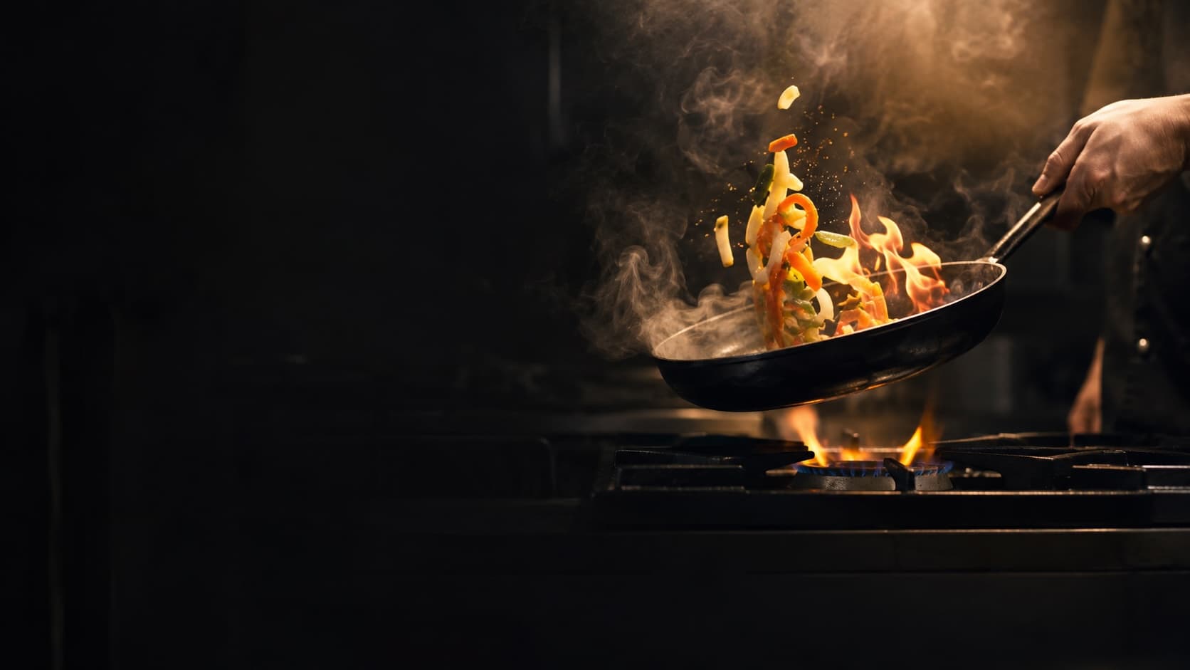 Une poêle fumante au-dessus de la flamme d'une cuisinière